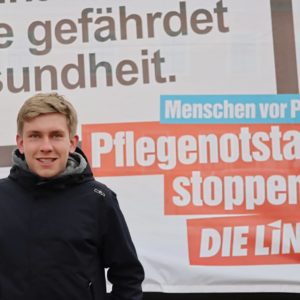 Philipp Rubach vor einem Großflächenplakat bei "Pflegenotstand stoppen!"